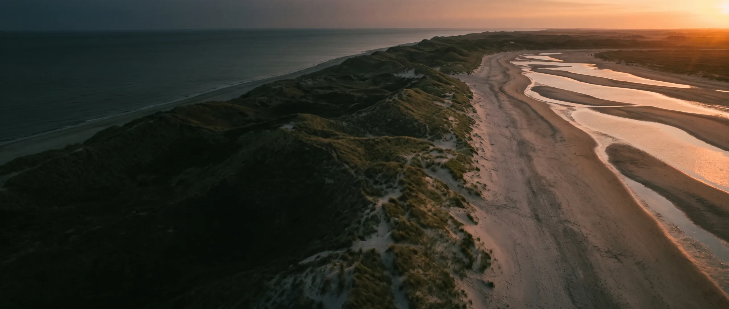 Luchtfoto van duinen en strand aan de Nederlandse kust tijdens het blauwe uur